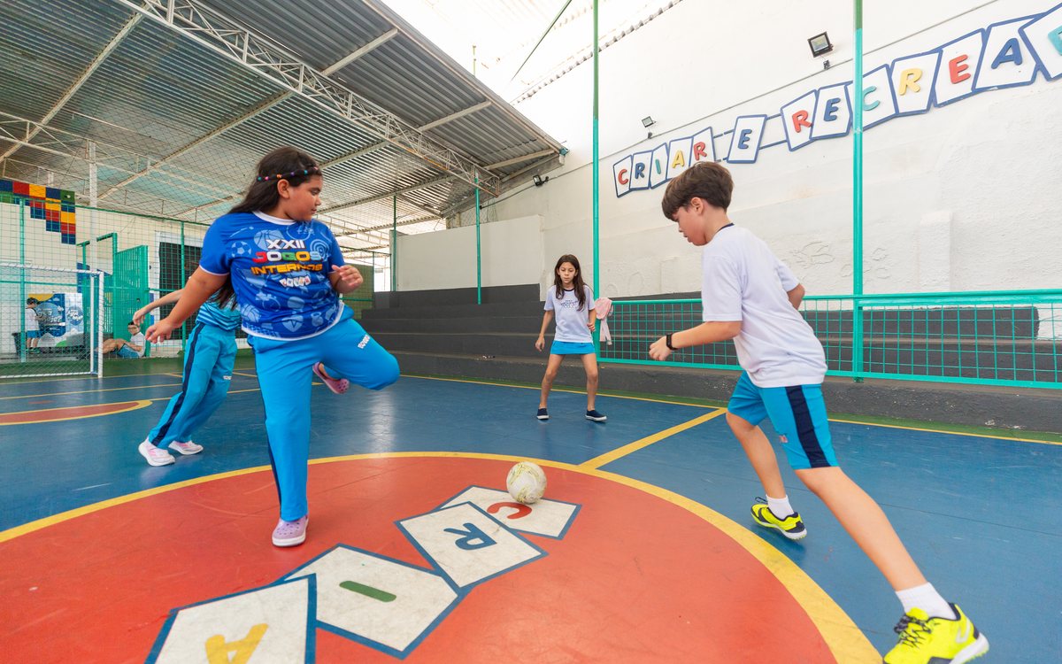 Alunos da Escola Criar jogam futsal na quadra coberta
